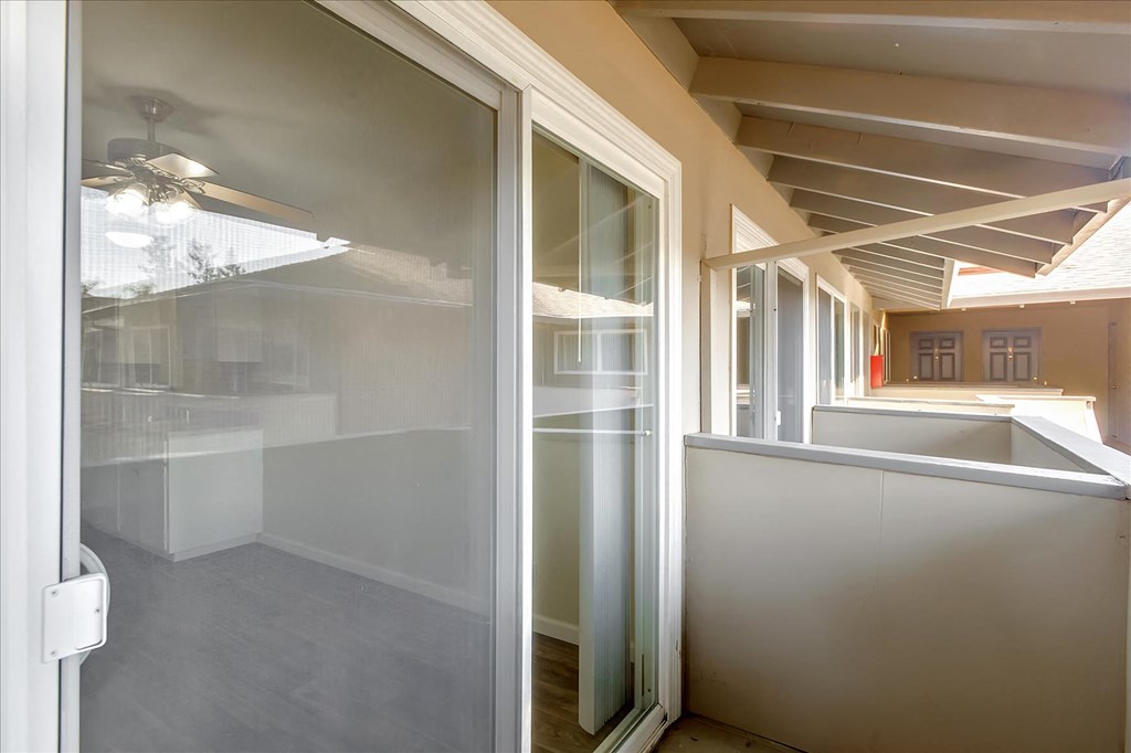 a glass door opens to a kitchen with a counter and a window
