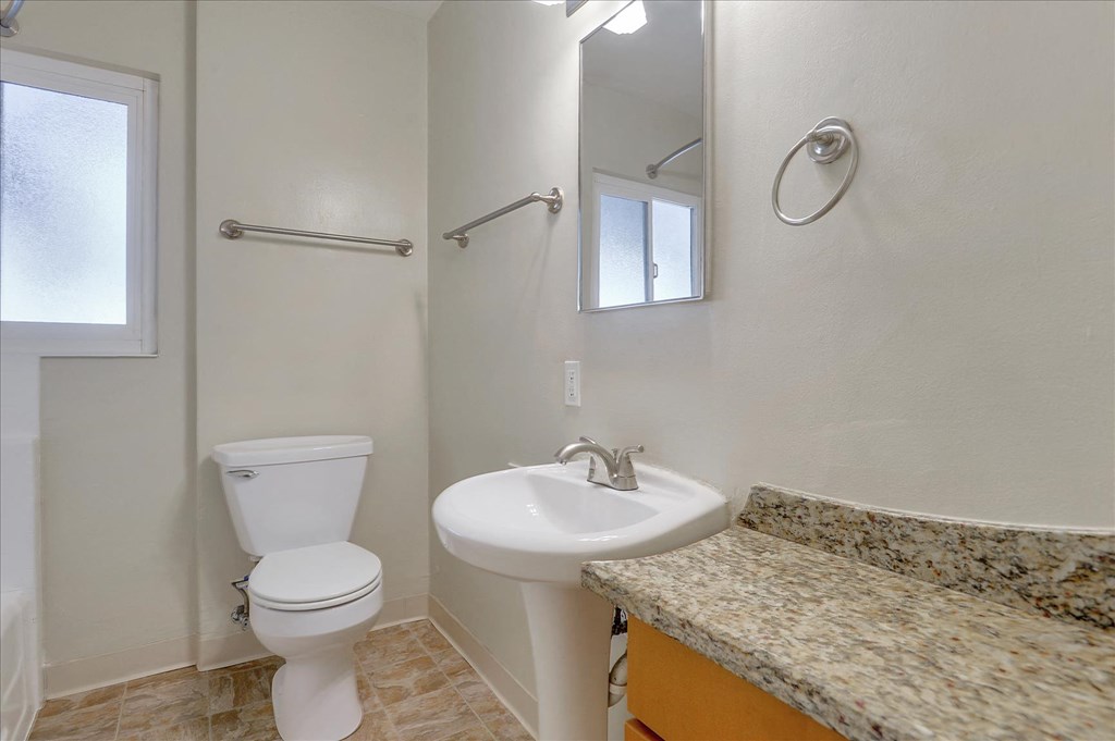 a bathroom with a sink toilet and a mirror