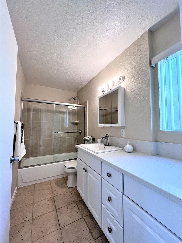 A bathroom with a white sink and a white toilet.