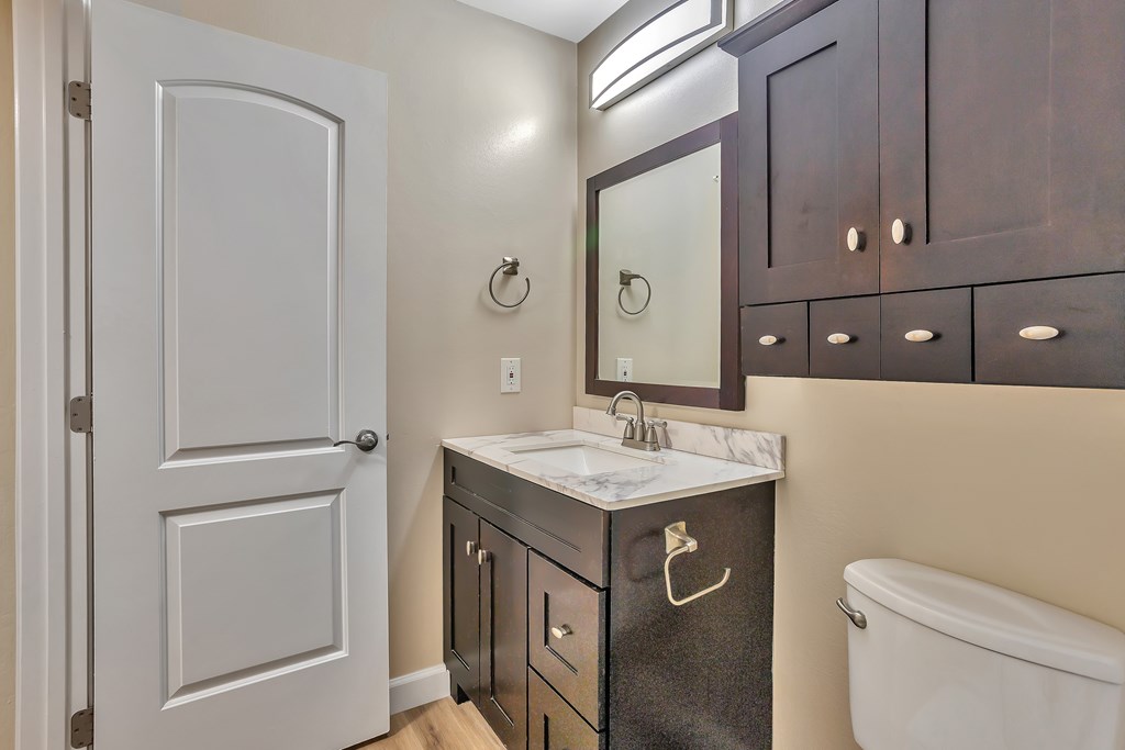 A bathroom with a white sink and a white toilet.