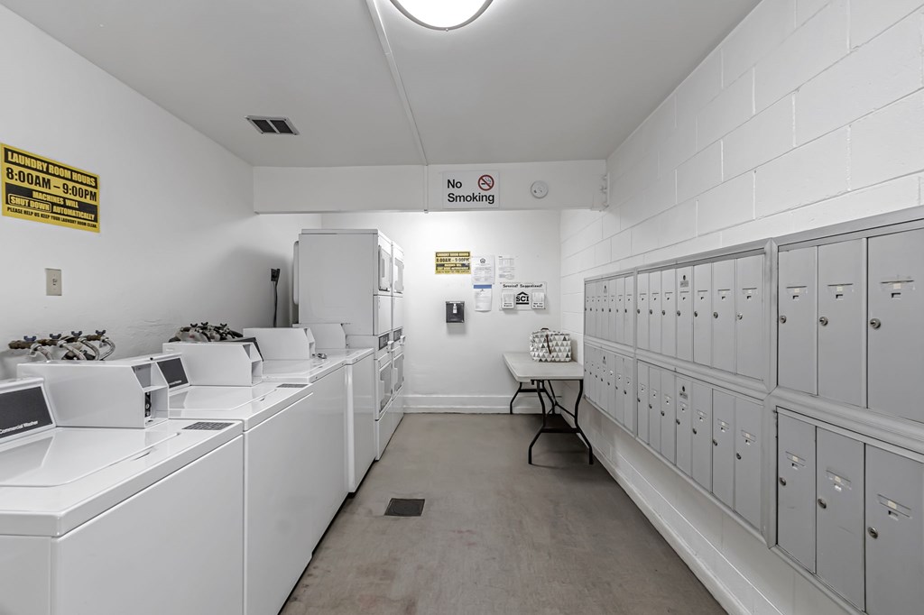 A laundromat with washers and dryers and a sign that says