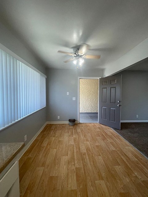 a living room with a wood floor and a ceiling fan