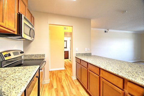 a kitchen with granite counter tops and wooden cabinets