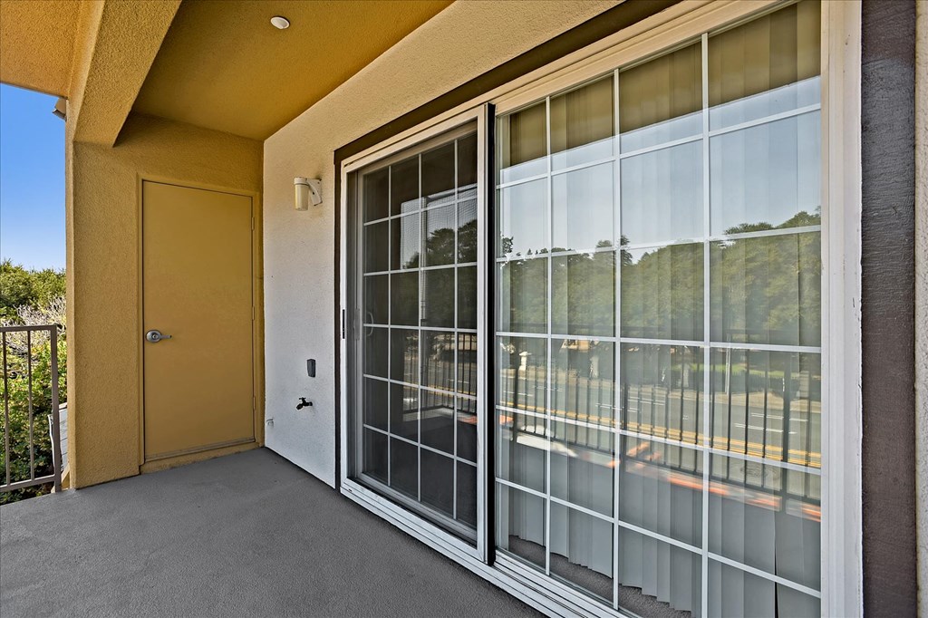 A yellow door is on the left of a glass window.