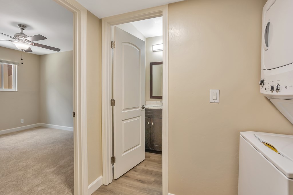 A white door is open to a kitchen area.