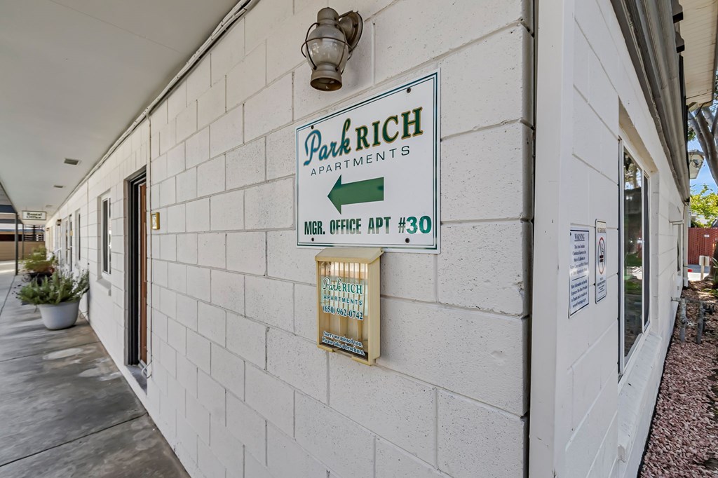 A sign on a building that says "Park Rich Apartments".