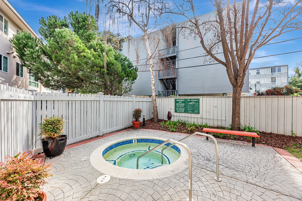 A small hot tub sits in the middle of a patio.