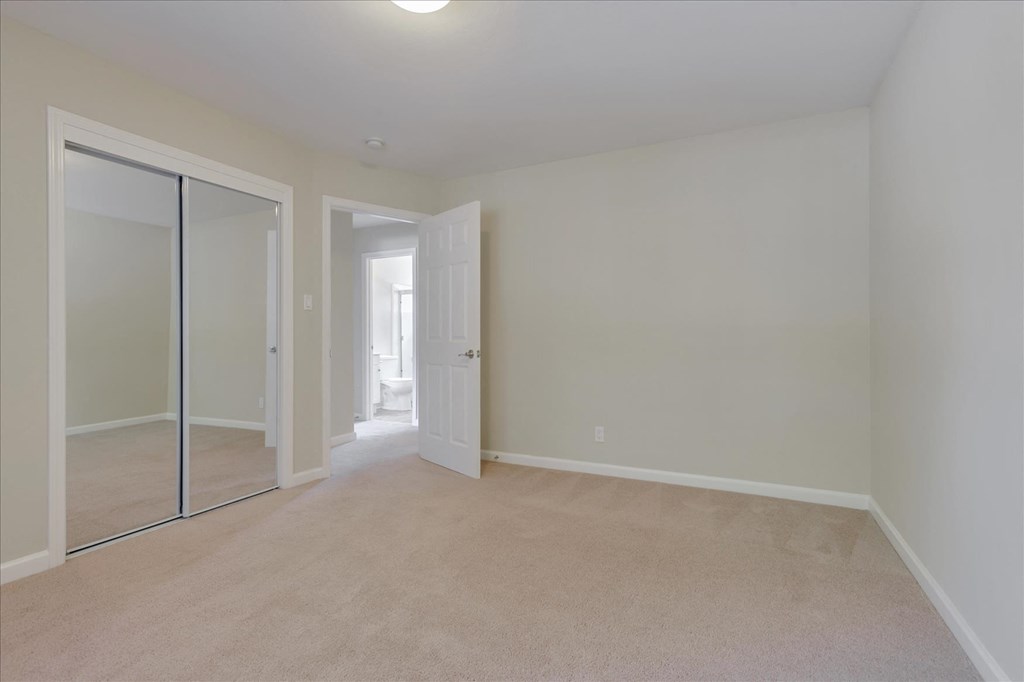 A room with a sliding glass door and carpeted floor.