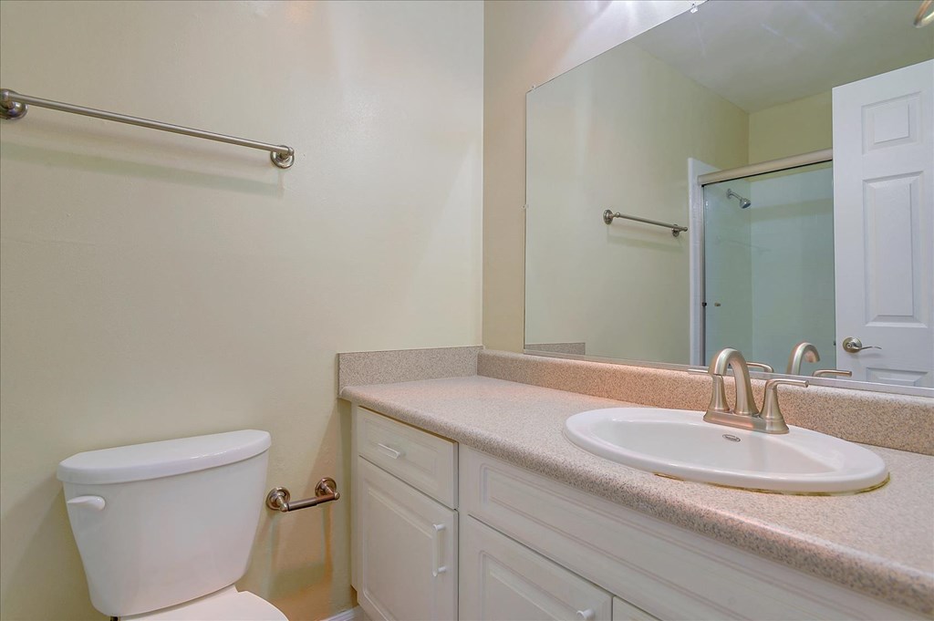 a bathroom with a sink toilet and a mirror