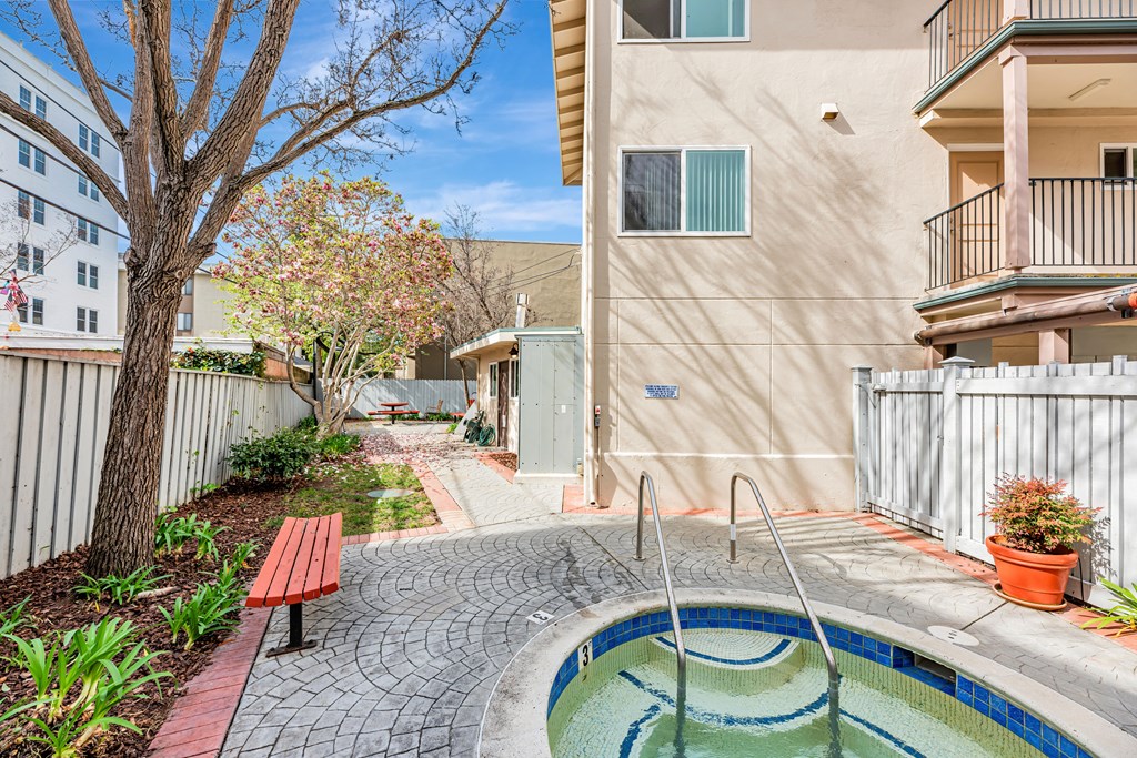A small pool in a courtyard surrounded by a fence.