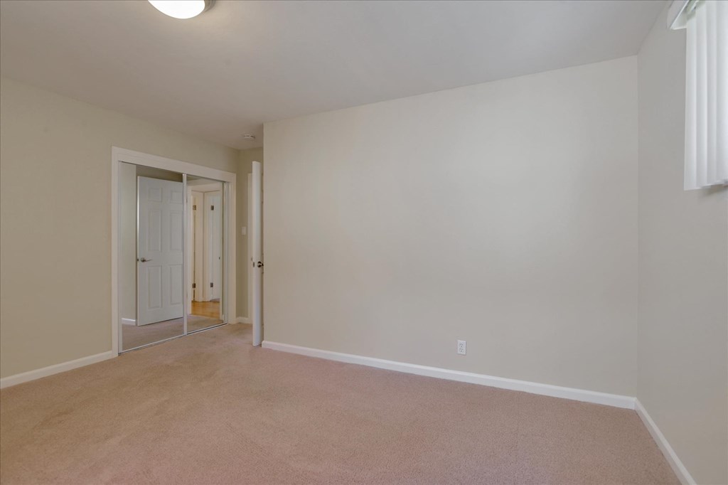 an empty living room with a door to a hallway