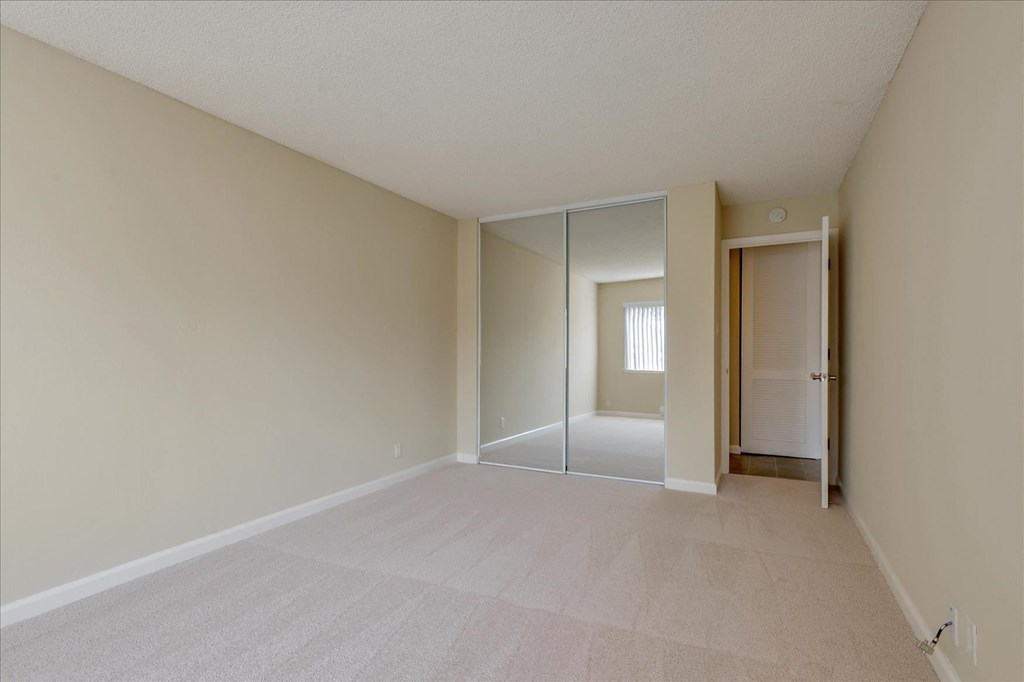 an empty room with a mirrored closet door