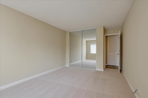 an empty room with a mirrored closet door