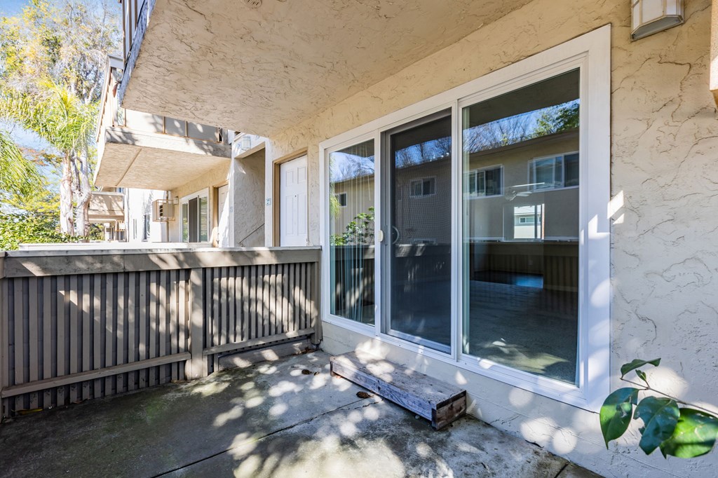 A patio with a white door and a wooden fence.