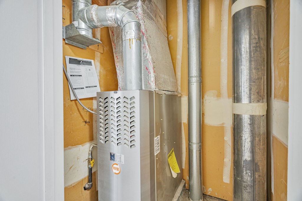 A wall with pipes and a ventilation system.