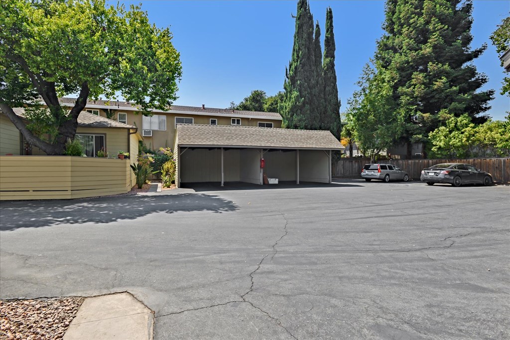 A parking lot with a building and trees in the background.