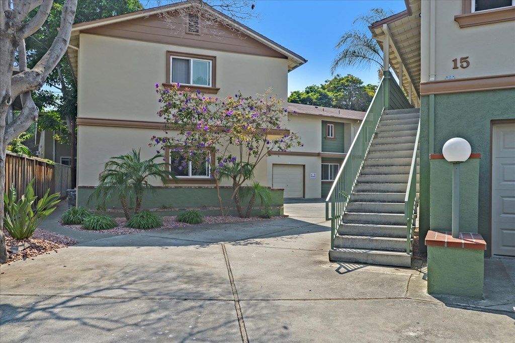 a driveway in front of a house with a staircase