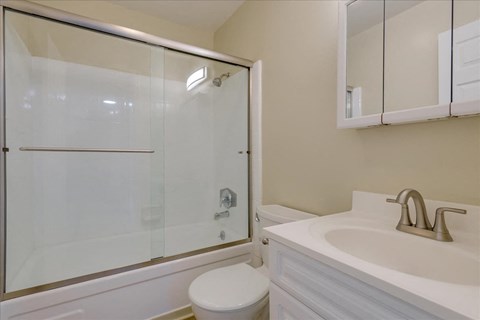 a bathroom with a shower and a sink and a toilet