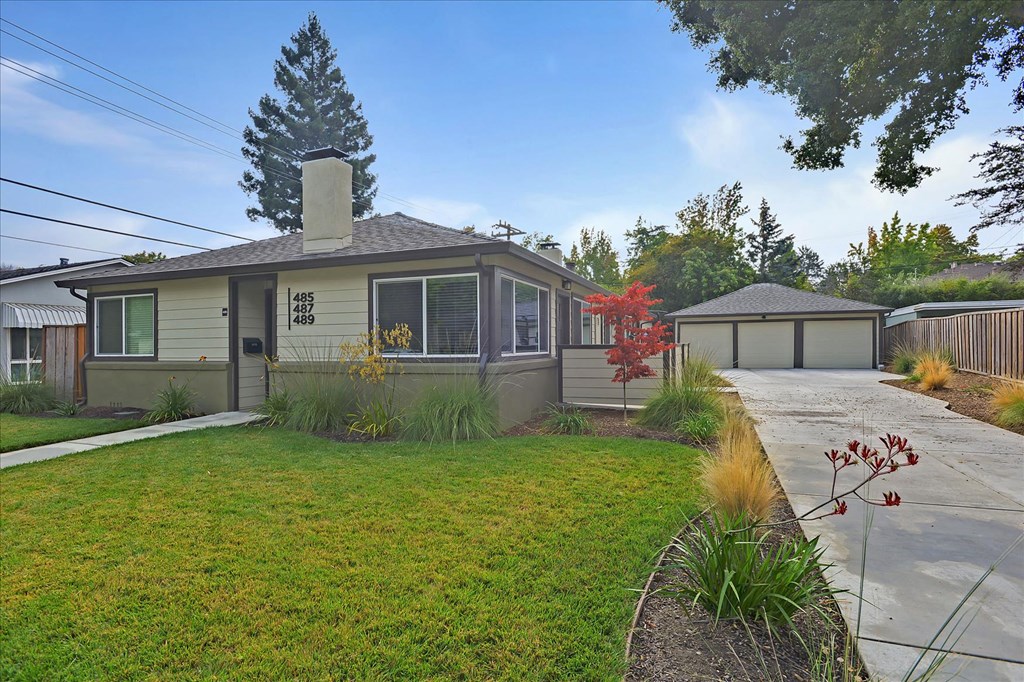 the front of a house with a yard and a driveway