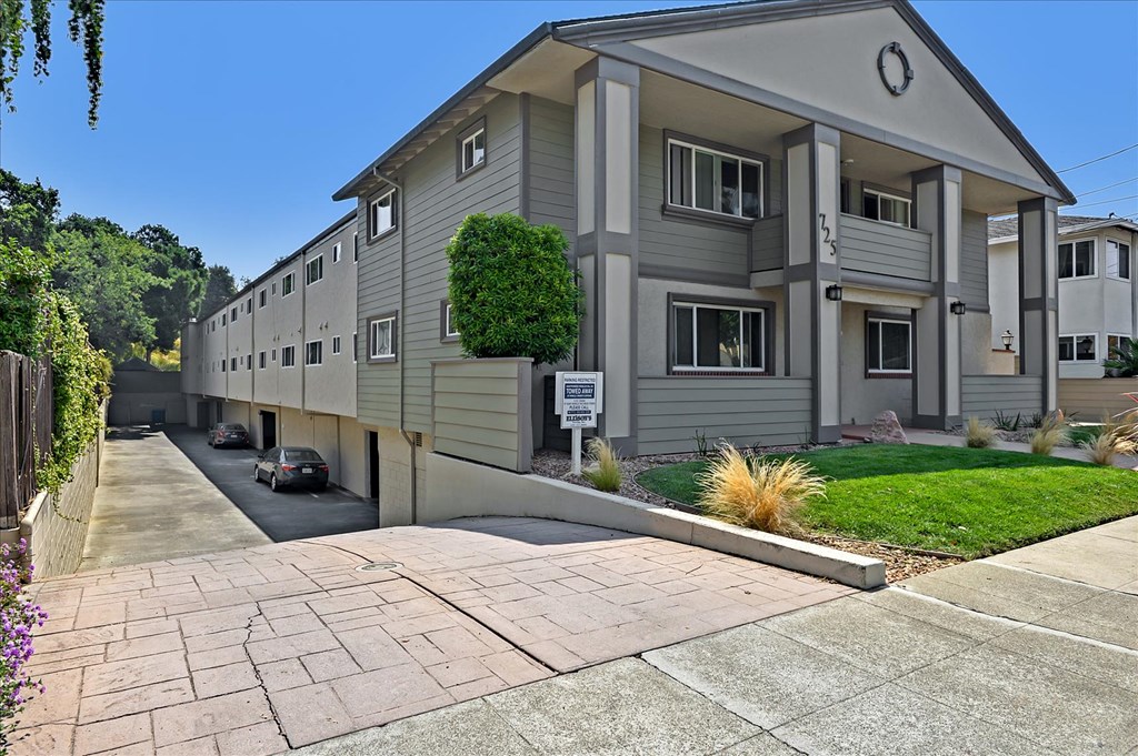 an apartment building with a driveway and a parking lot