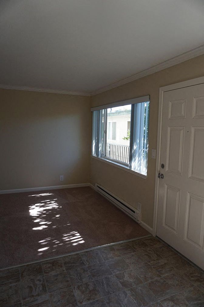 an empty living room with a window and a door