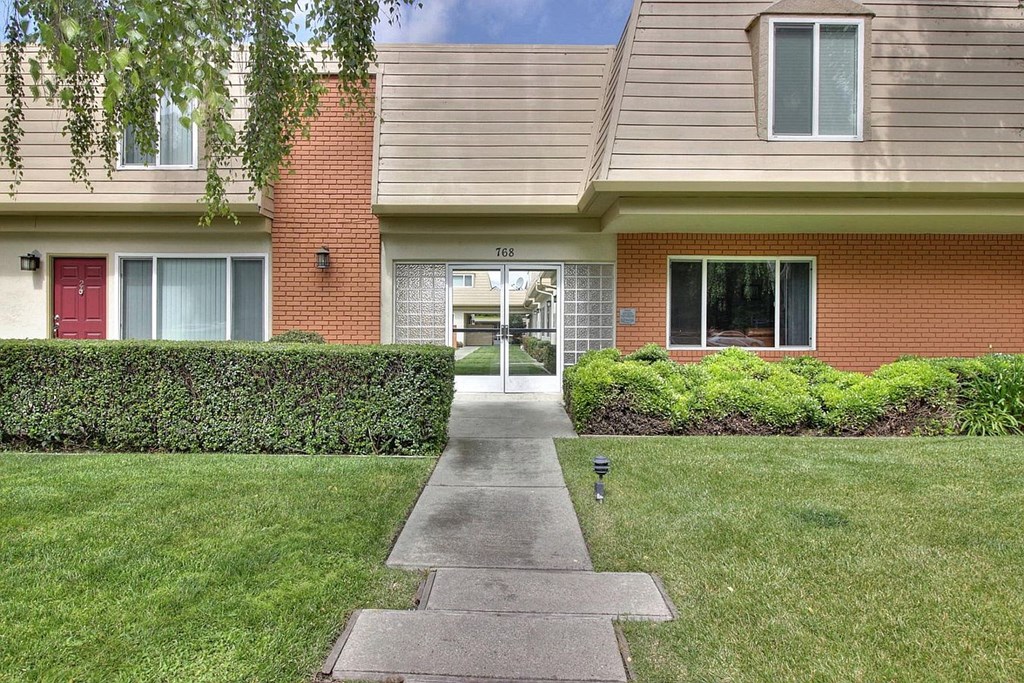 a sidewalk in front of a brick house