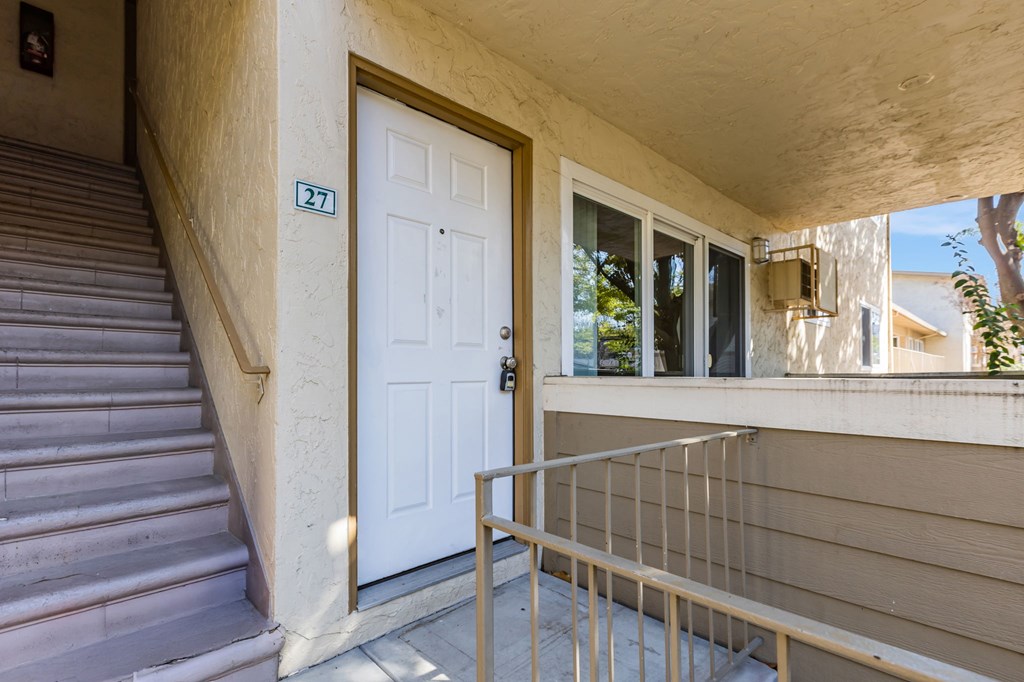 A white door with a number 27 on the wall above it.