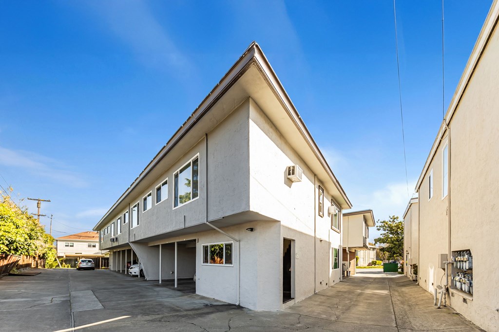 A white building with a triangular roof and a clear blue sky above.