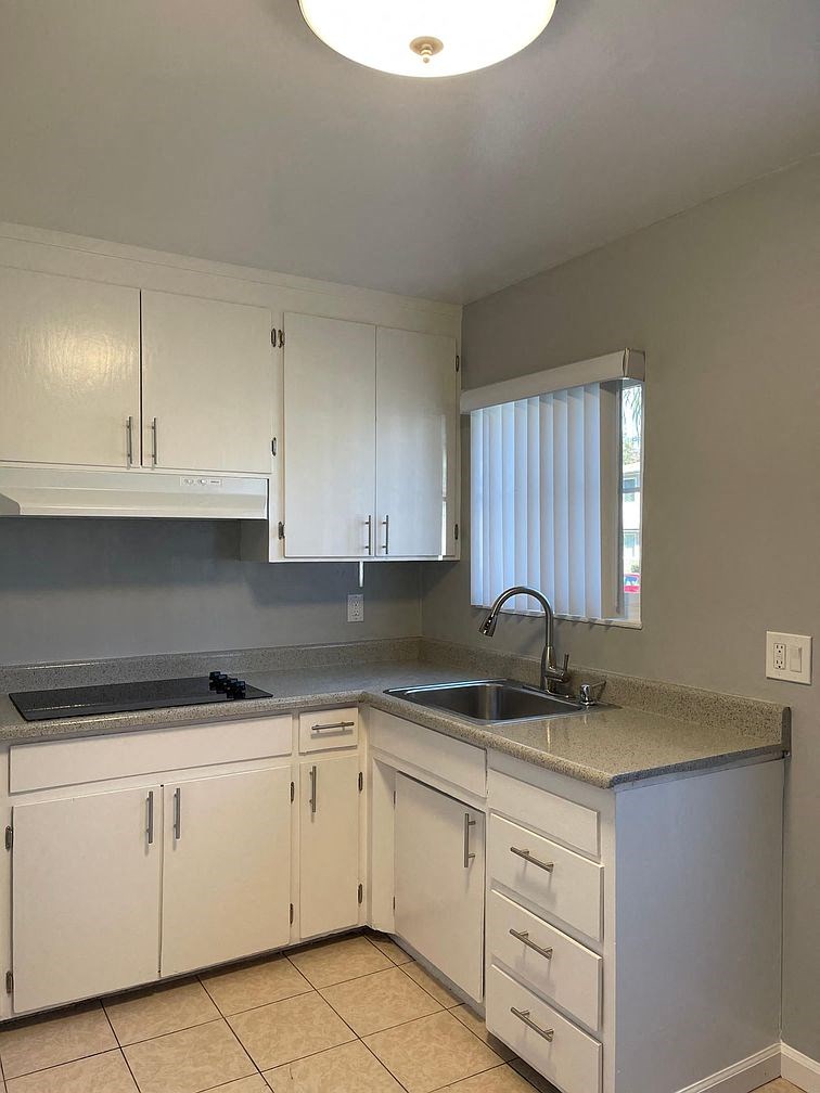 A kitchen with white cabinets and a granite countertop.