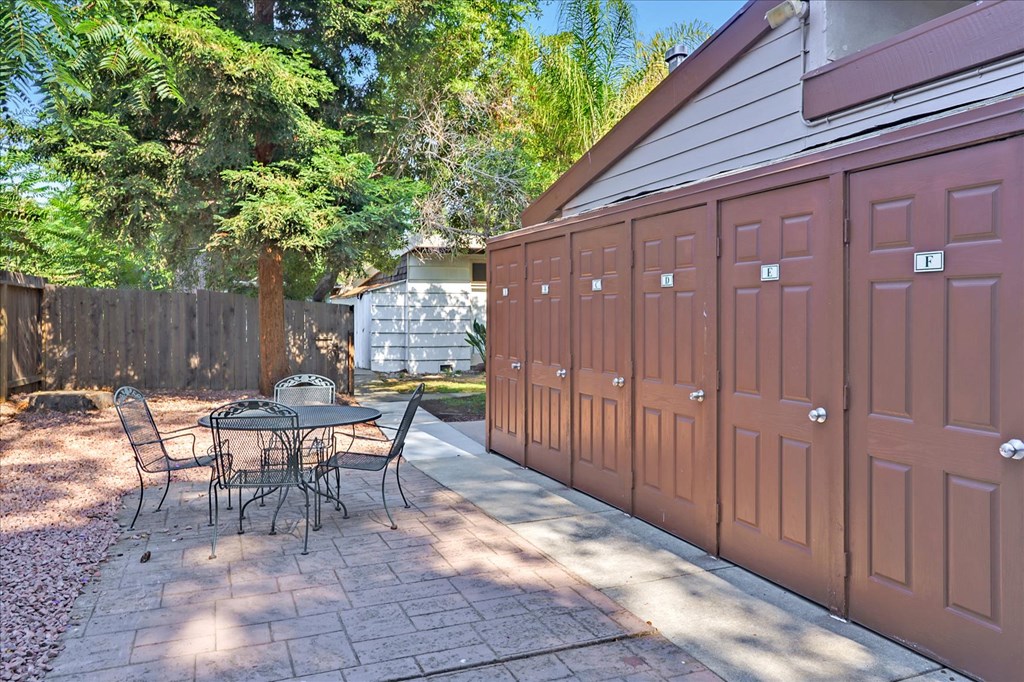 a patio with a table and chairs next to a garage