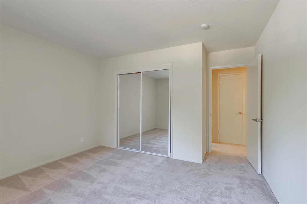 A room with a carpeted floor and a door on the right.