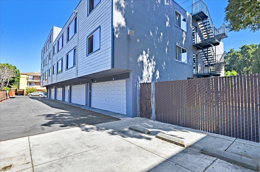 a white building with a fence on the side of a street