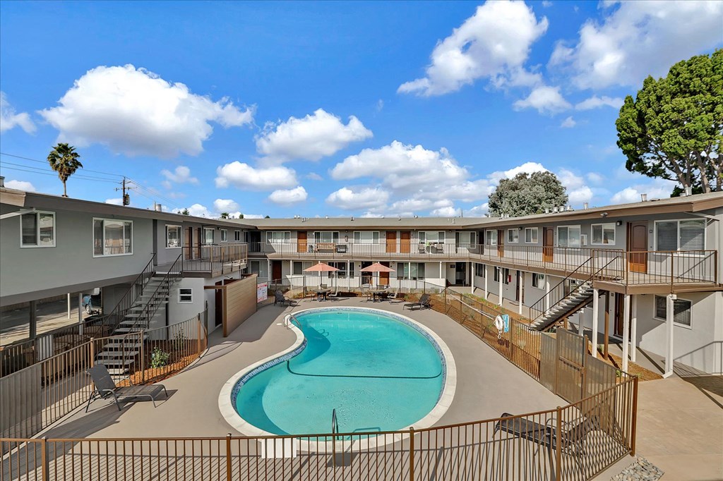 a swimming pool in a courtyard with a building in the background