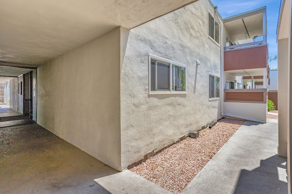 A concrete building with a red gravel area in front.