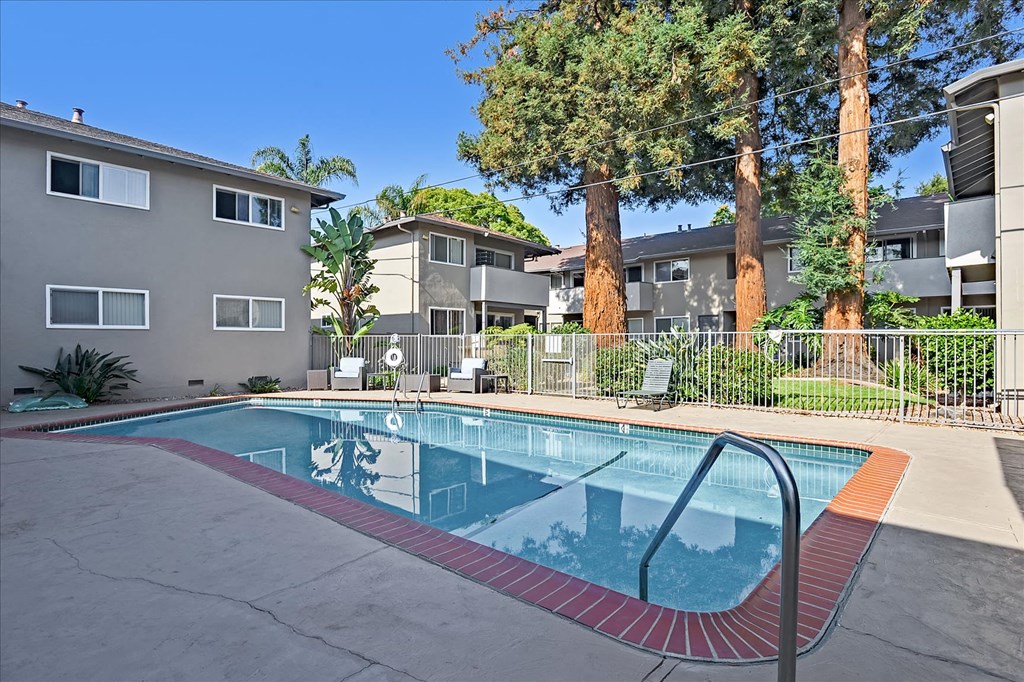 a swimming pool with an apartment building in the background