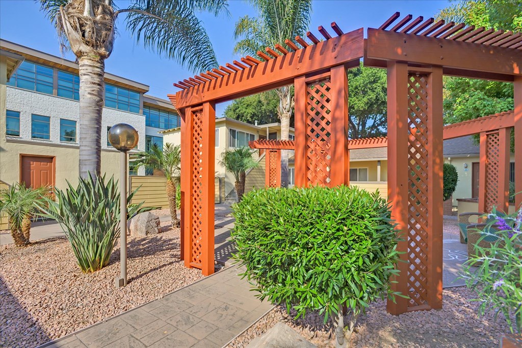 a gazebo with a bush in front of a house