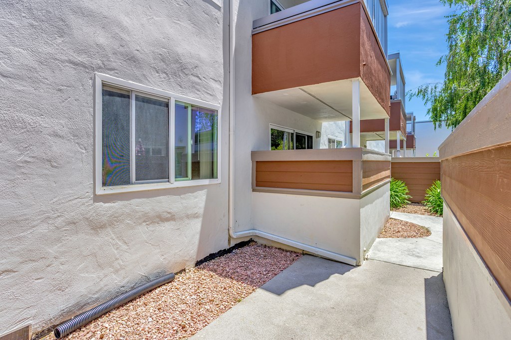A modern house with a white exterior and a brown balcony.