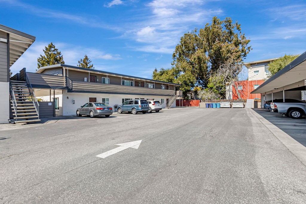 A parking lot with cars and a building in the background.
