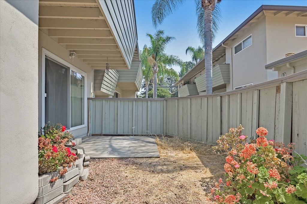 a patio with a fence in front of a house