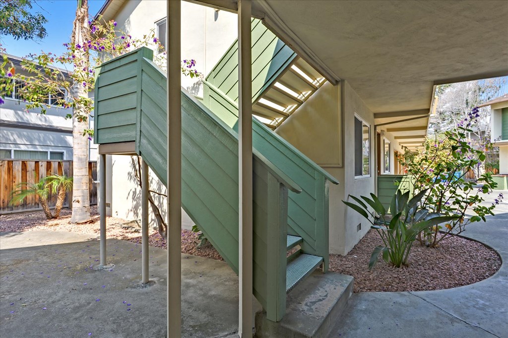 the entrance to a house with green siding and stairs