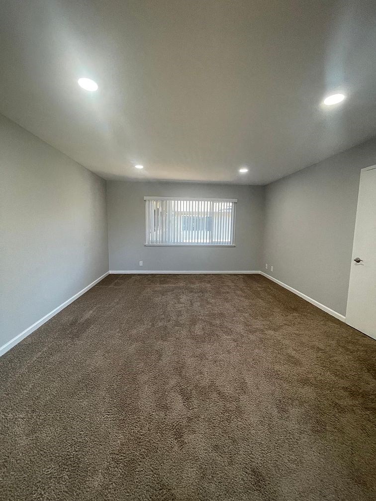 an empty room with carpet and a window