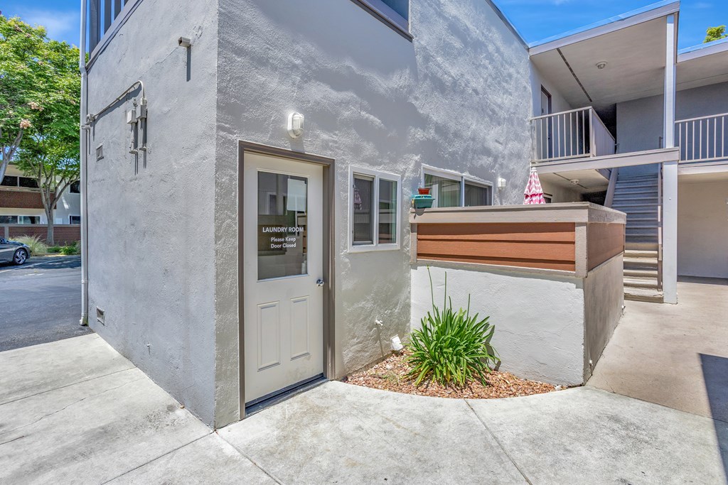 A modern house with a grey exterior and a brown bench in front.