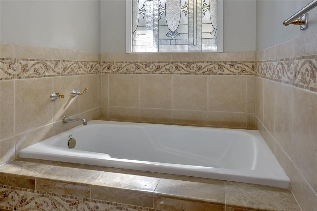 a large white bath tub sitting under a window
