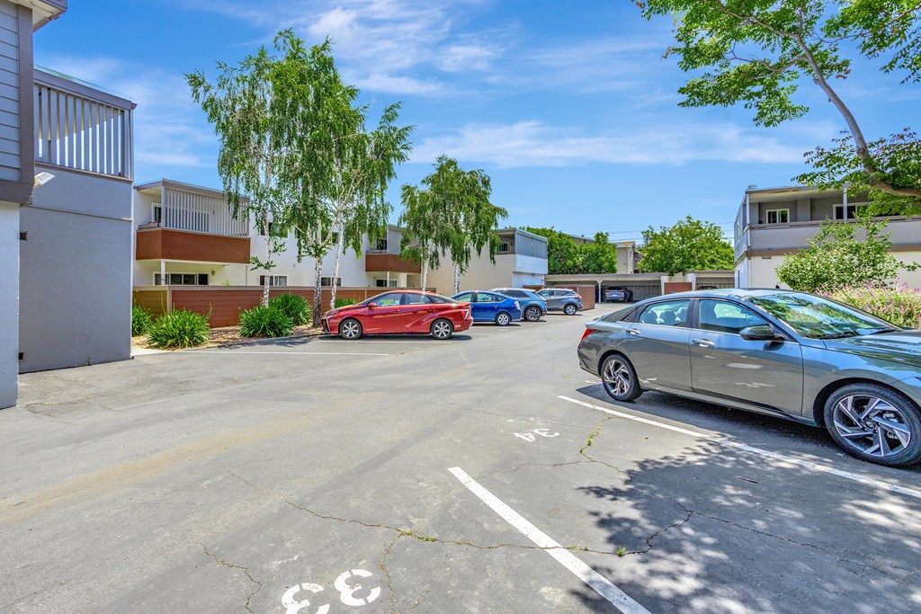 A parking lot with cars and a building in the background.