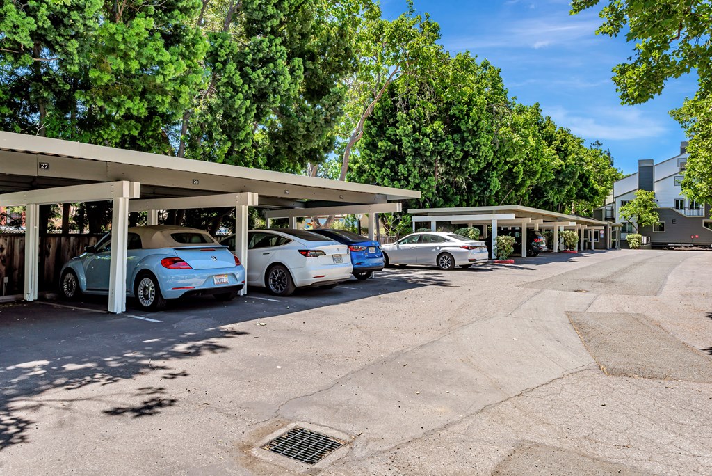 A parking lot with cars parked under a canopy.