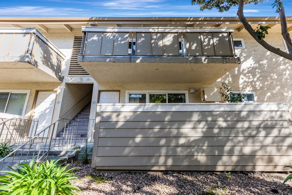 A modern house with a balcony and stairs leading to the second floor.