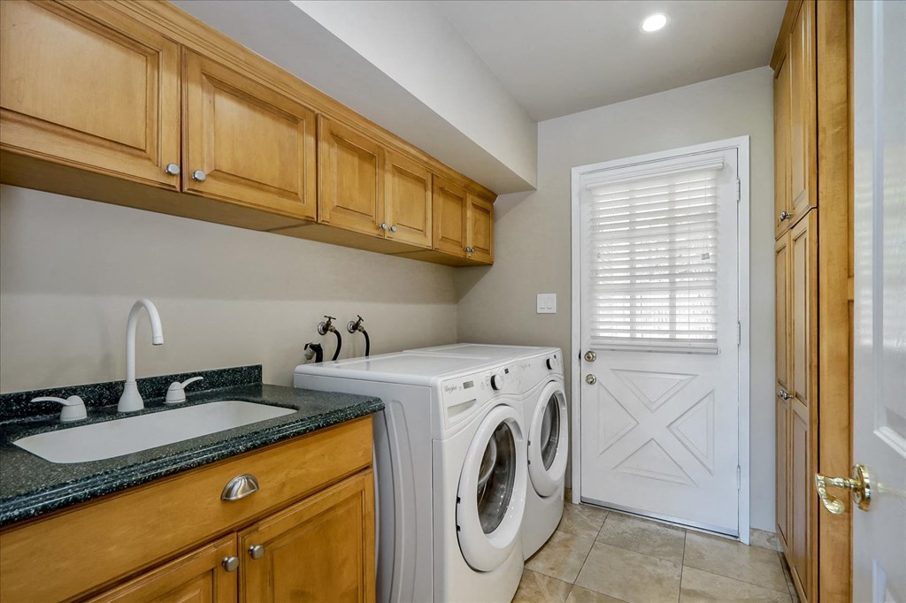 a laundry room with a washing machine and a sink