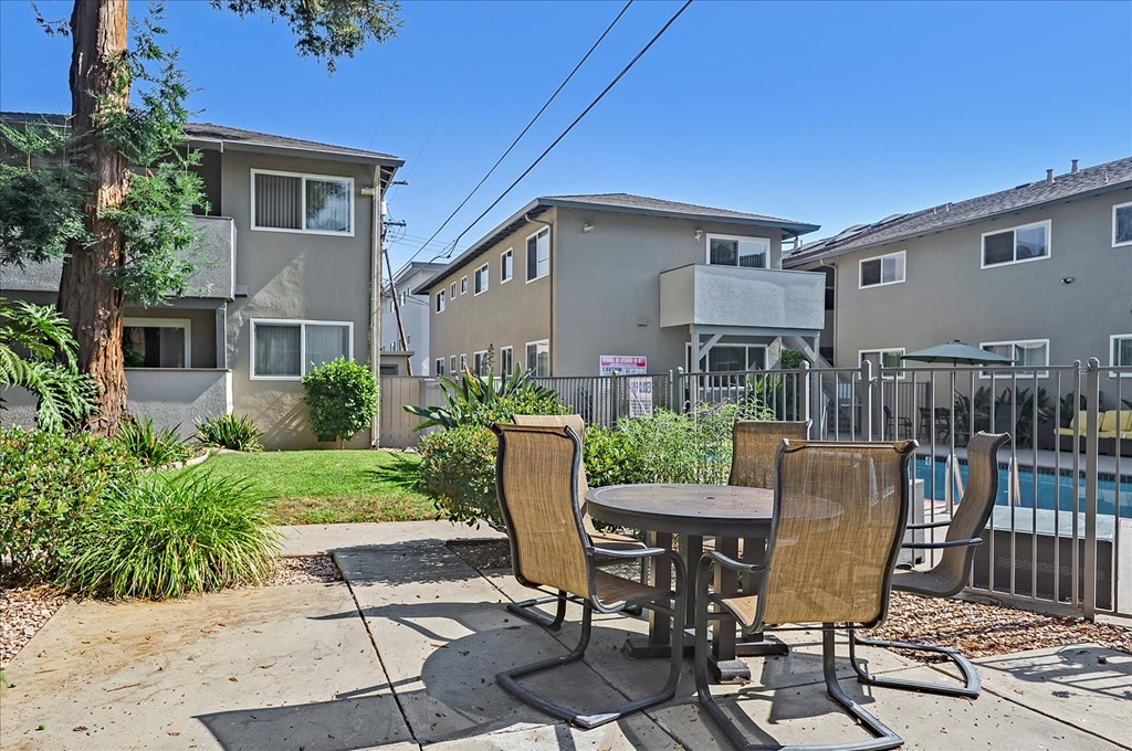 a patio with a table and chairs in front of some apartments