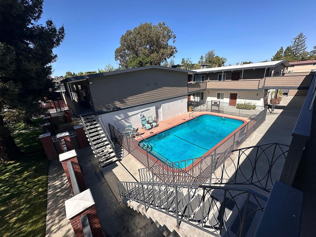 A pool surrounded by a fence and a building.