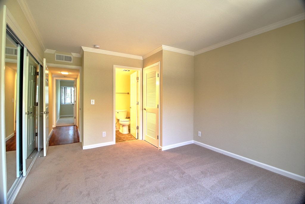 an empty living room with a closet and a bathroom